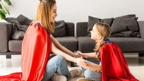 mom and daughter wearing superhero capes