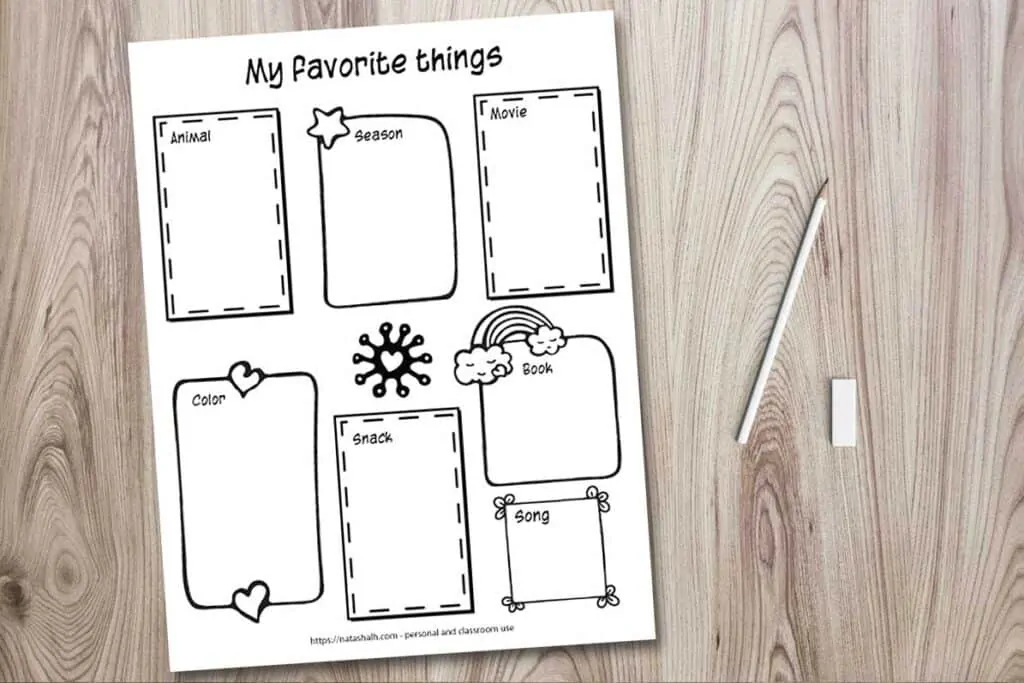 A printable worksheet mockup on a wood background with a cup of colorful pens, a pencil, and an eraser. The worksheet says "my favorite things" across the top ands seven hand drawn doodle frames for a child to write or draw their favorite animal, season, movie, color, snack, book, and song.