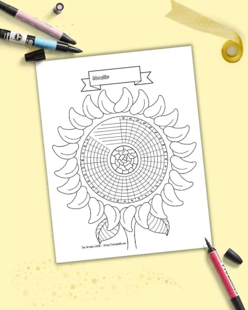 A sunflower themed circular habit tracker with 31 days. The page is on a light yellow background with a red, pink, and blue marker and gold ribbon.