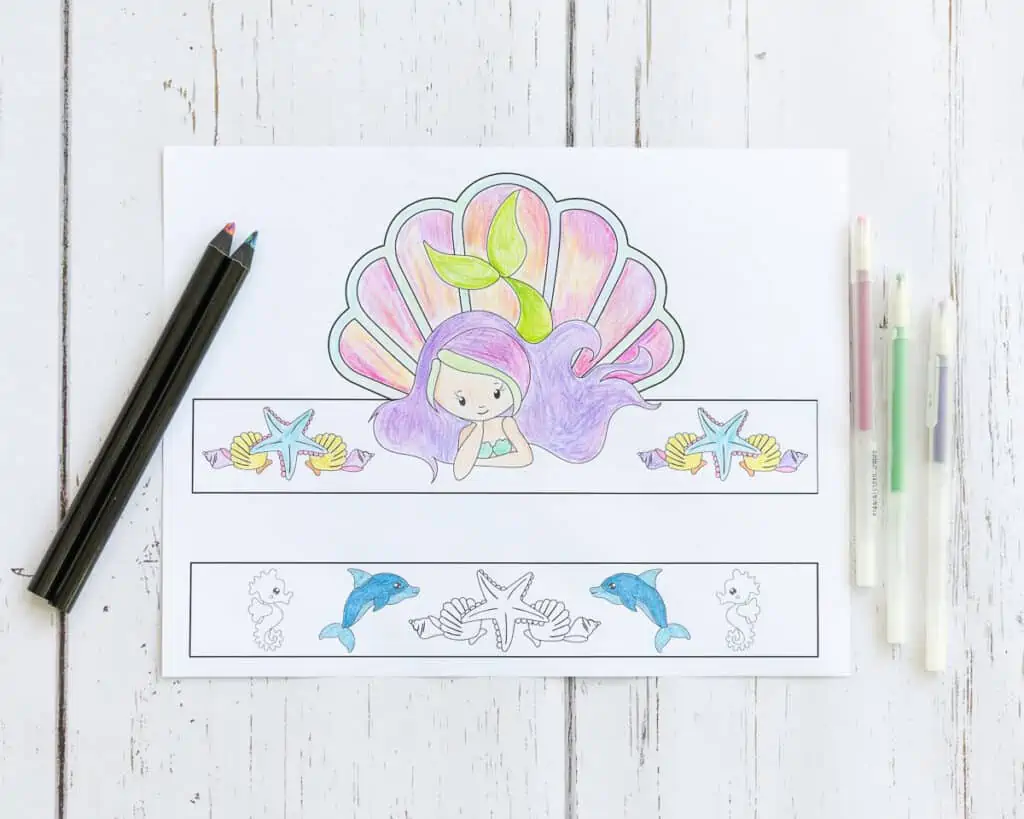 A preview of a partially colored mermaid crown printable with multicolor pencils
