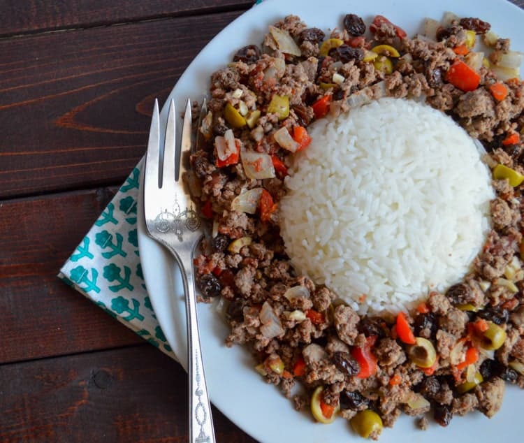 picadillo made with venison on a white plate and wood table