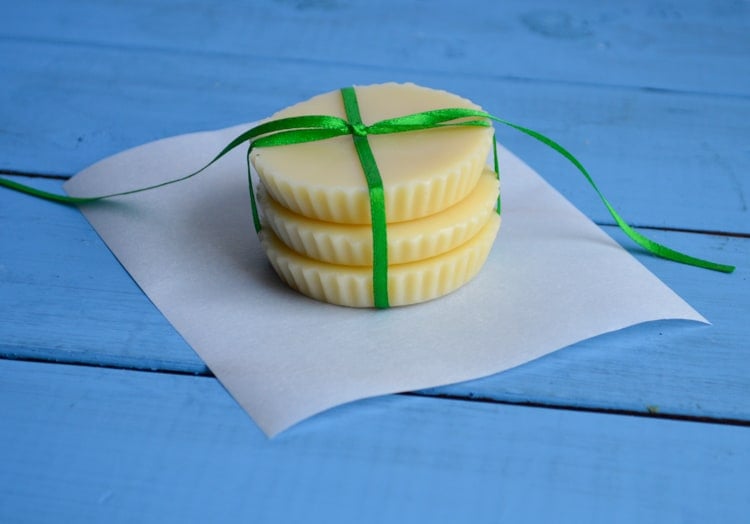 three beeswax lotion bars in a stack tied with green ribbon