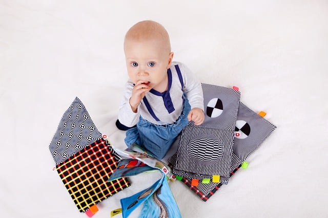 baby sitting in a pile of chewable cloth books