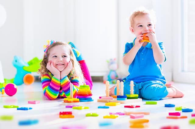 older toddlers playing with wood toys