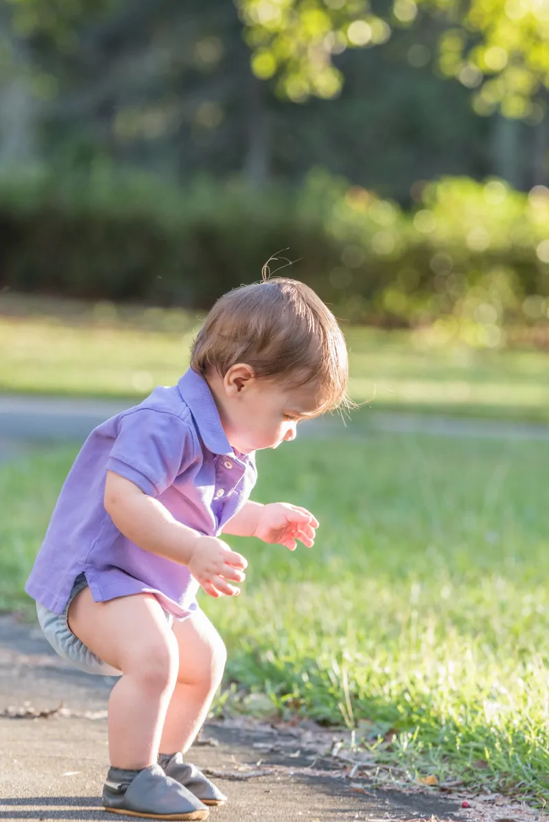 toddler playing in grass