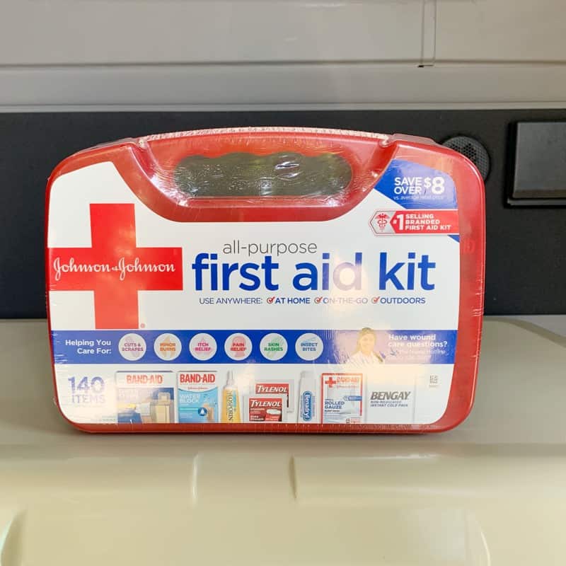 red first aid kit on top of an ice chest