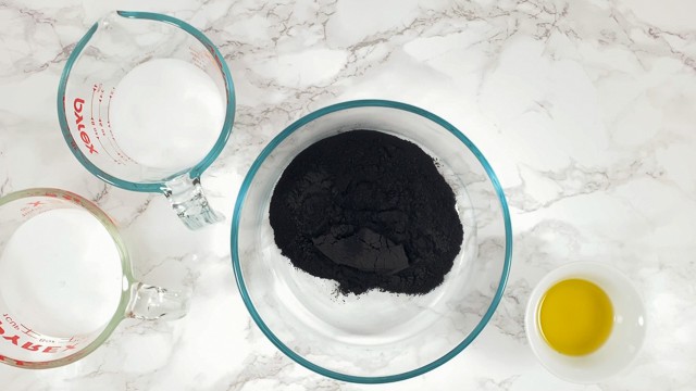 Activated charcoal in a mixing bowl to make black bath bombs
