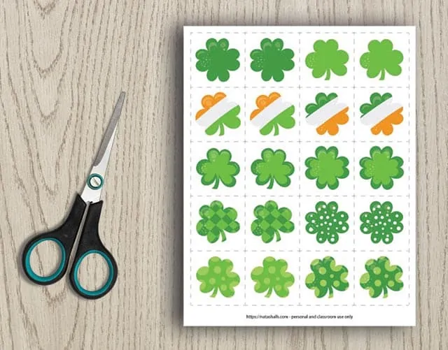 printable shamrock matching card game with 10 different shamrock images on a wood background next to scissors 