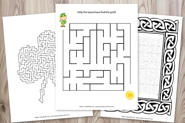 Three printable mazes for St. Patrick's Day on a wood background. One maze is easy, one is shaped like a shamrock, and the third maze is difficult