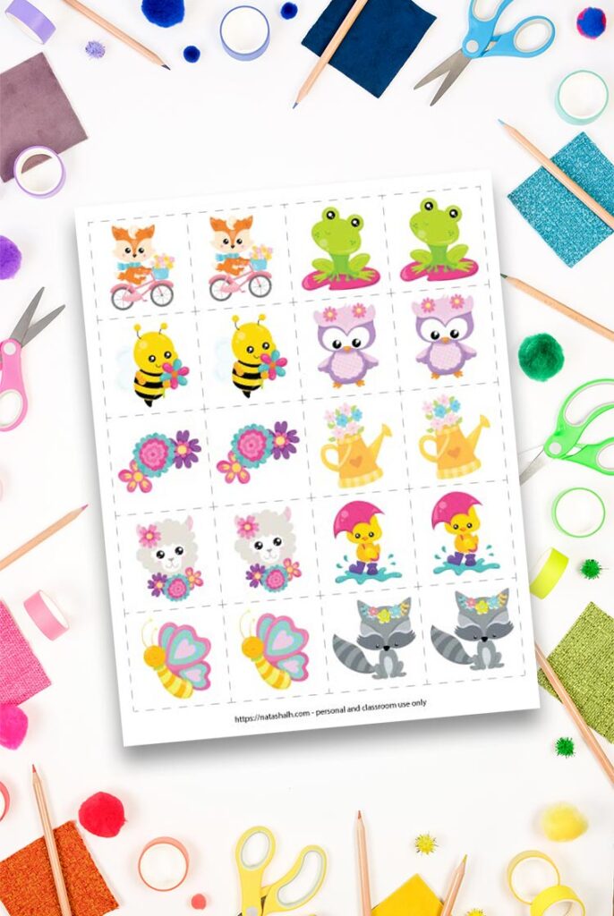 spring printable memory game with 10 different spring cartoon animals and flowers on top of a workspace with colorful children's scissors, washi tape, and pencils