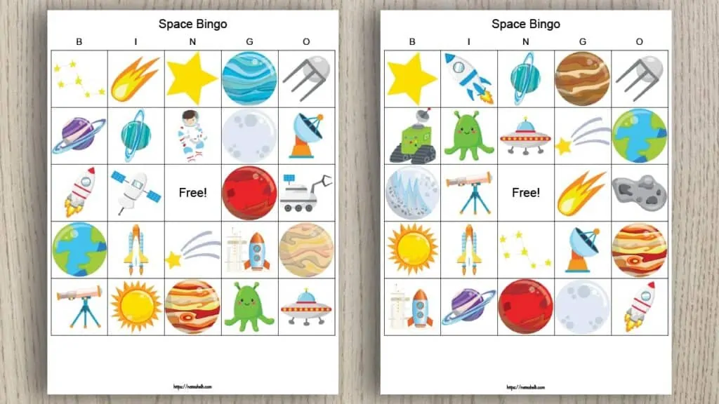 Two free printable space bingo boards on a wood background. The bingo cards feature cartoon space-themed images like planets, stars, satellites, and telescopes.