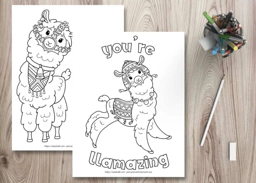 Two free printable llama coloring pages on a wood background. There is a cup full of pens in the top right. Below the pen cup is a pencil and an eraser. The coloring pages are layered on top of one another. The front page says "you're llamazing" in bubble letters with a jumping llama waring a blanket and chulo hat. The page behind is partially obscured and has a front-facing llama wearing a bell and halter made of flowers. 