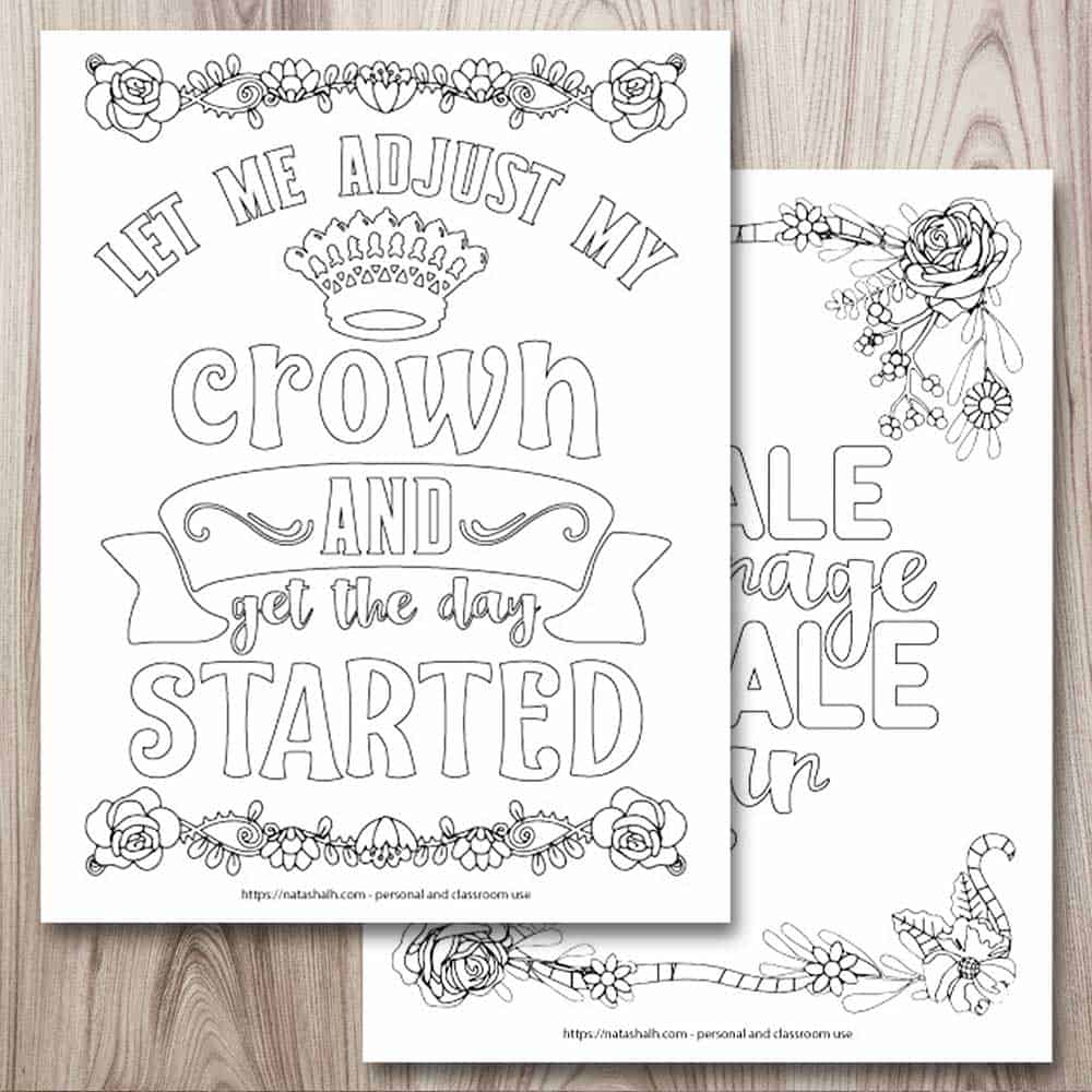 A mockup of two printable inspirational quote coloring pages on a wood background. In the top left is a page with a crown, a floral border, and the text "let me adjust my crown and get the day started." Behind this page, and partially obscured, is a page with a floral border and the text "inhale courage exhale fear"