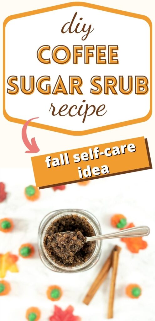 Text "diy coffee sugar scrub recipe - fall self-care idea" below the text is a jar with a coffee sugar scrub and a small metal spoon. The jar is surrounded by fall leaves, candy pumpkins, and cinnamon sticks.