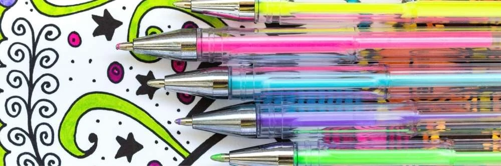 five neon bright gel pens on top of a partially colored coloring page with green swirls and pink dots