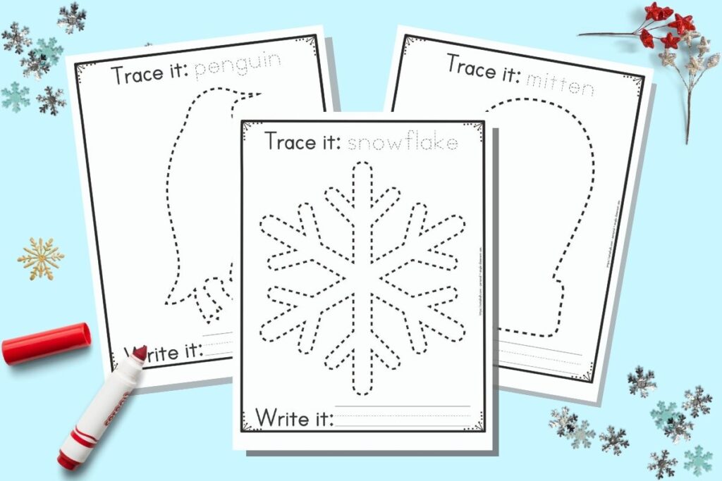 Three free printable winter themed tracing images for preschoolers and kindergarteners. The front and center page has a dotted snowflake to trace. It has the caption "Trace it: snowflake" on top and "write it" with a blank line for writing below the snowflake. Behind the snowflake are a penguin and a mitten to trace on separate pages. The printables are on a blue background with snowflake confetti and a red child's marker.