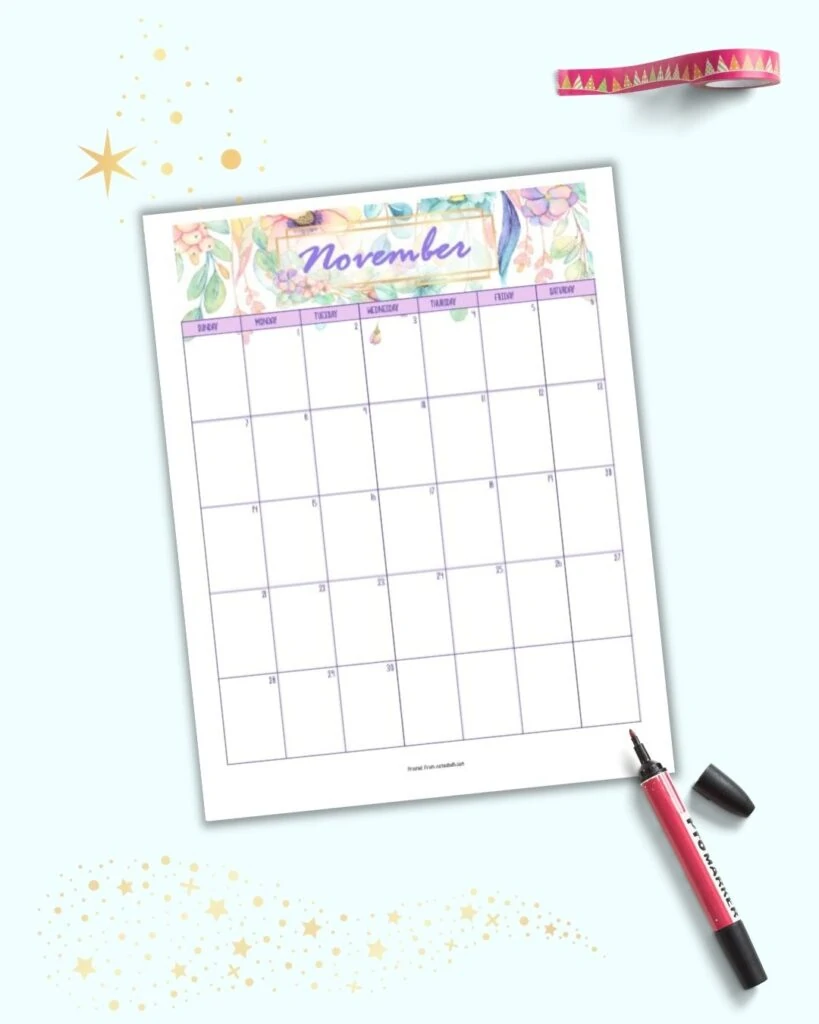 a free printable floral themed calendar page for November 2021. It is shown on a light blue background with ar ed marker and a roll of red wasabi tape