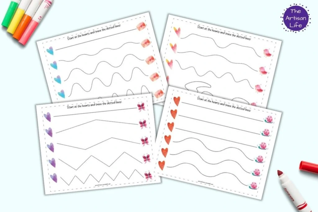 A flatlay mockup with four printable Valentine's Day tracing worksheets. Each page has a row of five hearts on the left followed by five dotted hearts to trace. Pages include straight, wavy, and zig-zag lines. The pages on a blue background with child's markers.