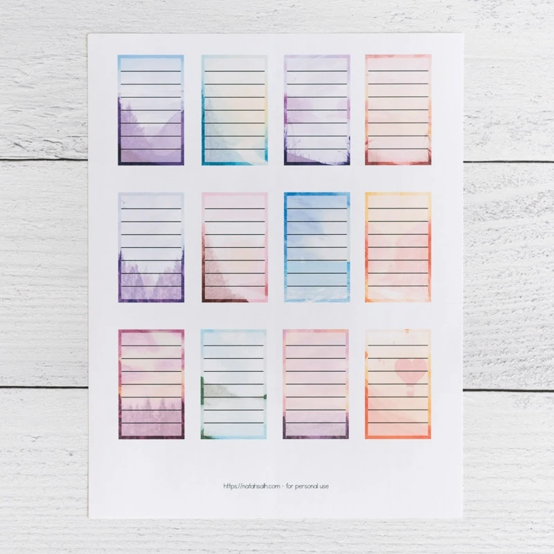 A printed page of 12 full box planner stickers for Happy Planner Classic. Each box has a watercolor landscape background and a translucent white rectangle with seven lines to write on.