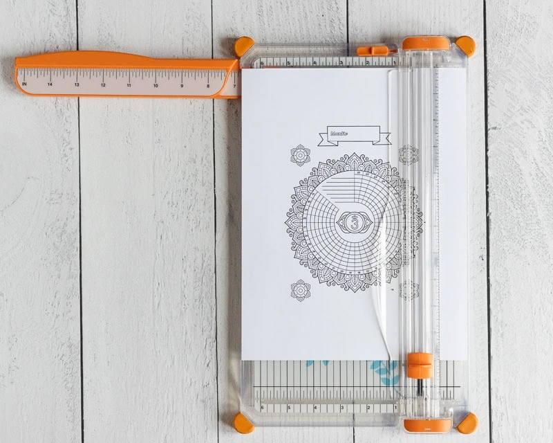 A printable habit tracker on a paper trimmer. The paper trimmer is on a white wood surface. 