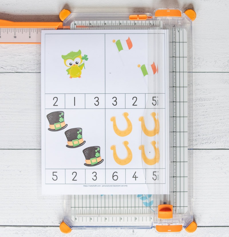 A page with four count and clip cards on a paper trimmer. The cards have St. Patrick's Day images 1-4 with numbers to clip with the correct quantity. 