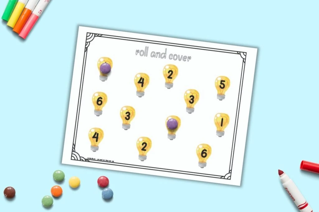 A printable roll and cover mat for preschool math. The page has the numbers 1-6 two times apiece. Each number is in the center of a light bulb. Purple round candies cover two of the numbers and an additional pile of candies is on the bottom left of the image.