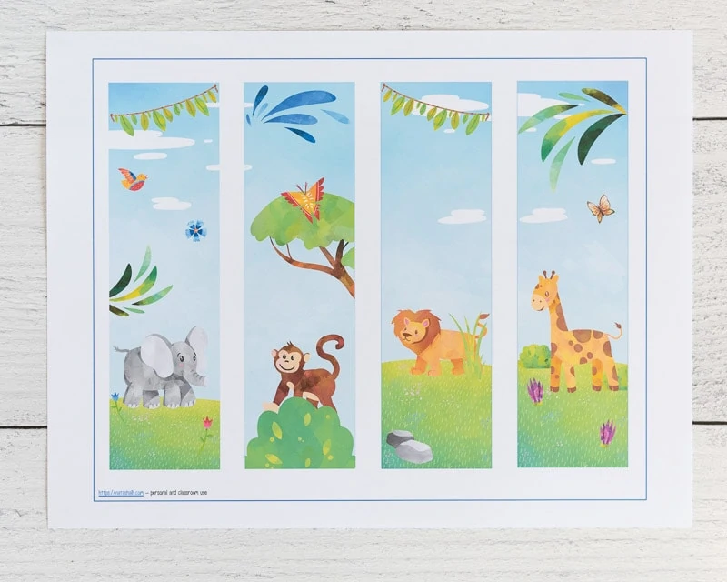 Four printable bookmarks on one printed page. Each bookmark has an African safari animal - an elephant, a monkey, a lion, and a giraffe 