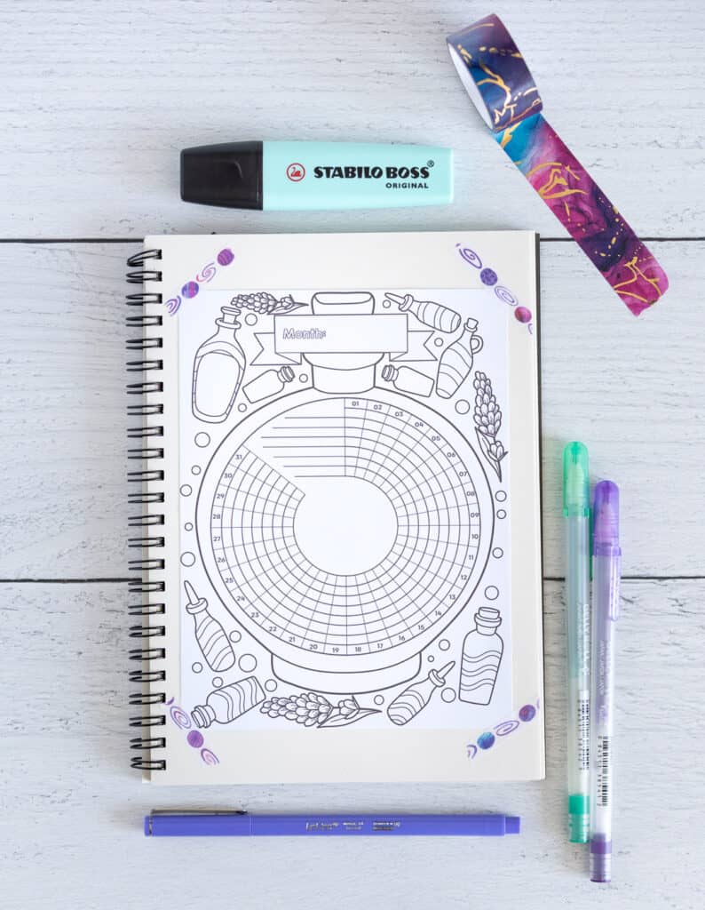 A printable bujo style habit tracker with 31 days. It is decorated with lavender flowers and lavender essential oil bottles. The page is taped in a small notebook surrounded by pens and washi tape.