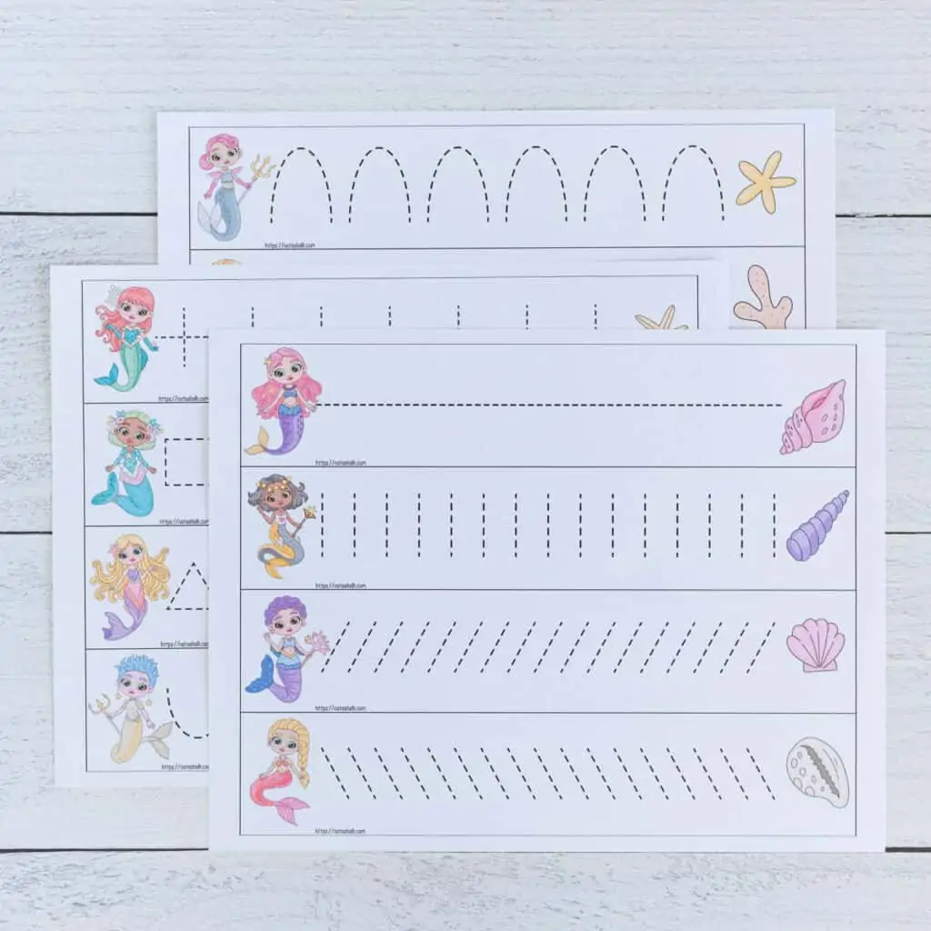 A preview of three pages of printable mermaid themed prewriting practice cards for preschoolers. Each page has four cards to cut out and trace. There is a mermaid on the left of each card and a shell on the right. Each card has a different dotted shape or line to trace. The pages are on a white wood background. 