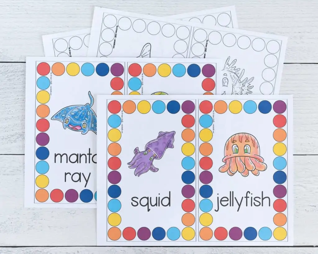 Four pages of ocean theme roll and count printables. Two are color, two are black and white. Each page has two cards to cut apart and use. The center of each card is an ocean animal. Around the outside is a rectangle comprised of large circles to count and color.