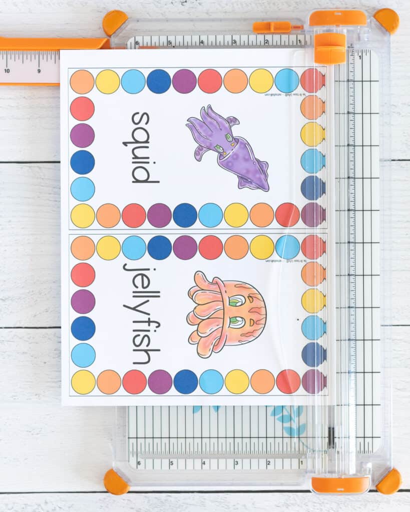A page with two ocean theme roll and count mats on a paper trimmer. The cards each have a colorful ocean animal surrounded by a rectangle made of circles to count and cover.