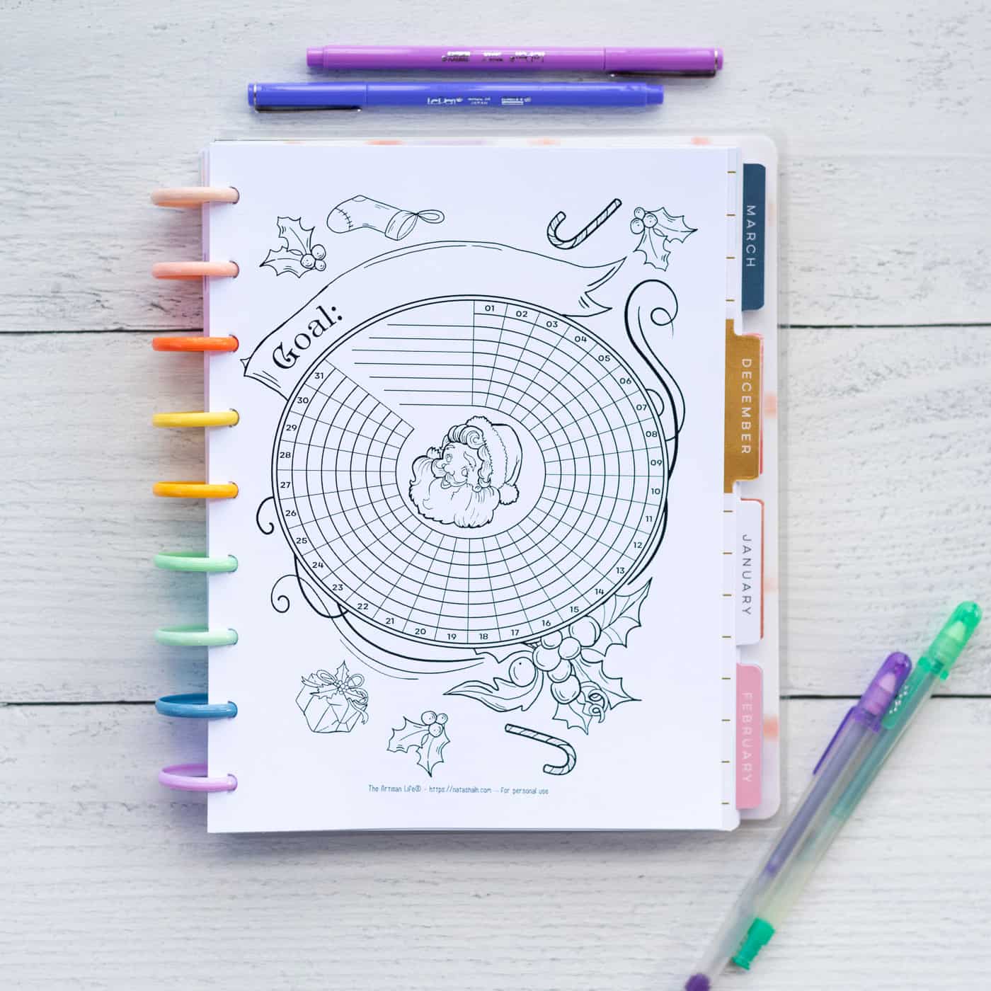 A Happy Planner Classic with a printable habit tracker page with vintage Santa graphics