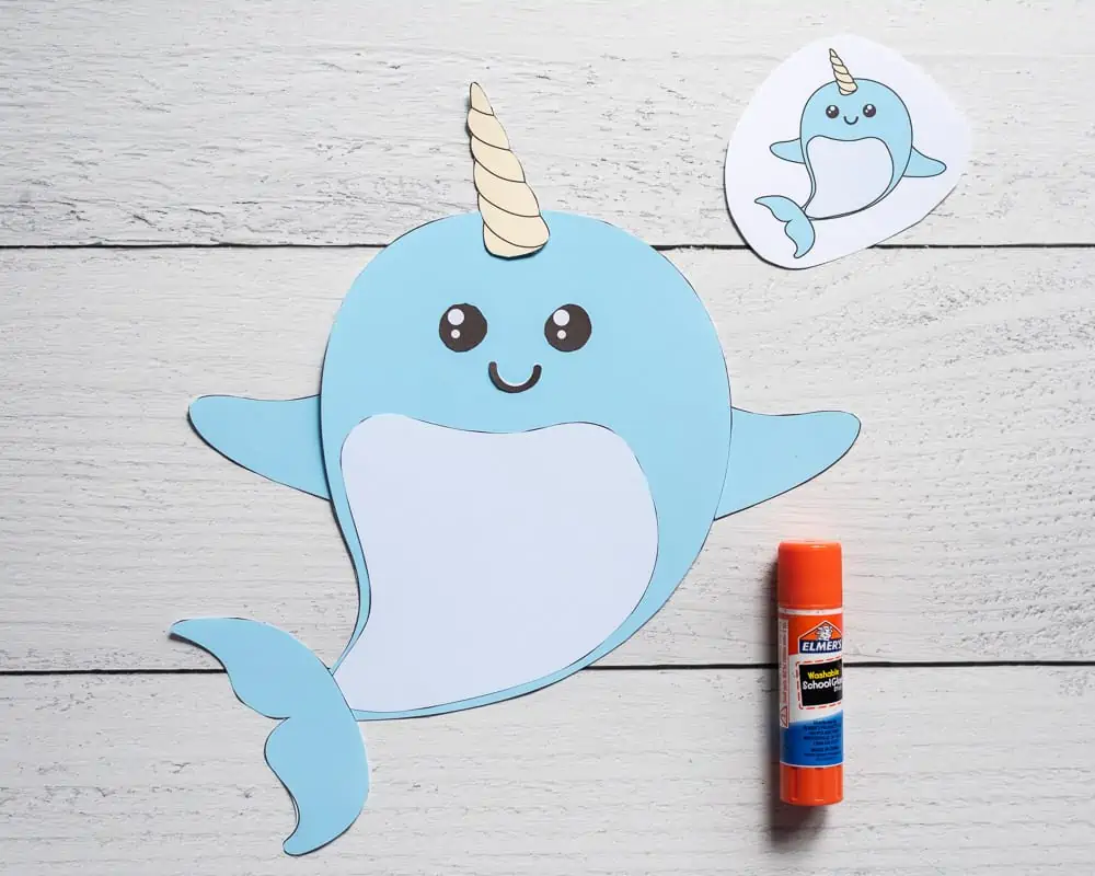 A completed cut and paste narwhal craft with a glue stick