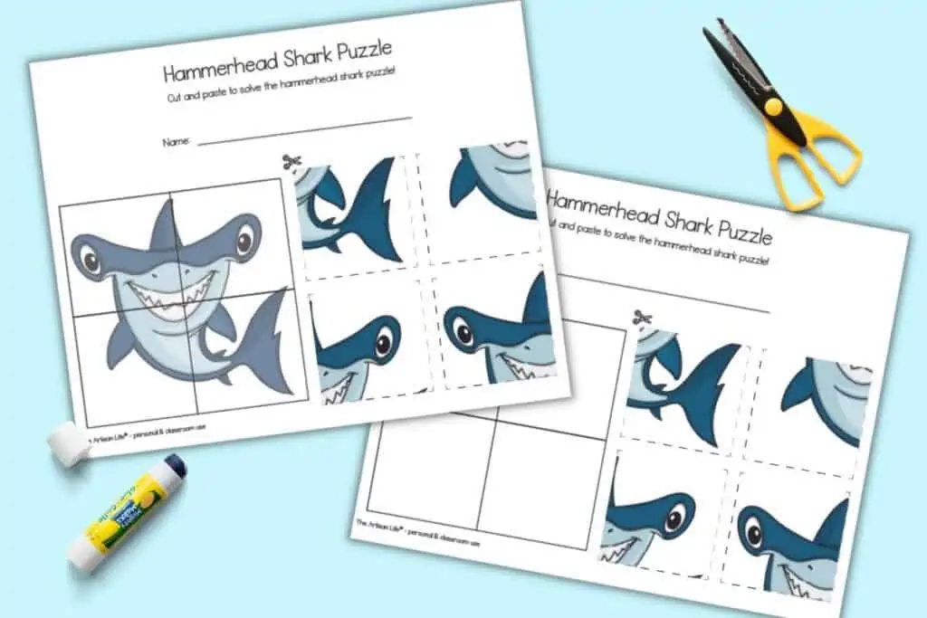 A preview of two pages of hammerhead shark cut and paste puzzle. Both puzzles have 4 pieces to cut and paste. One puzzle has a hint image in the solutions box, the other page does not have a hint image. The pages are shown with yellow handled scissors and a glue stick.