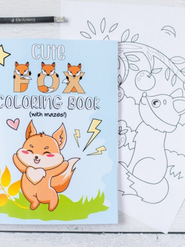 A children's fox coloring book shown with two pages removed, a metal ruler, and a hobby knife