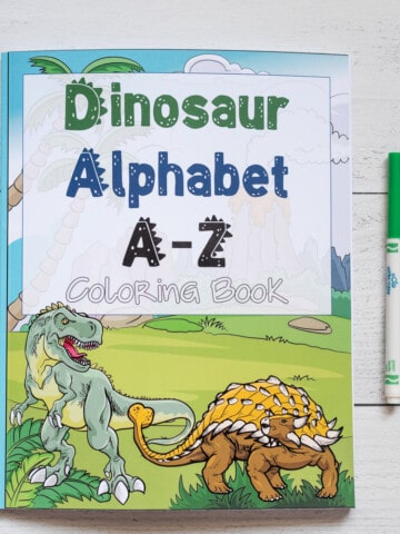 A preview of a Dinosaur Alphabet A-Z coloring book. It is on a white wood background with three children's markers