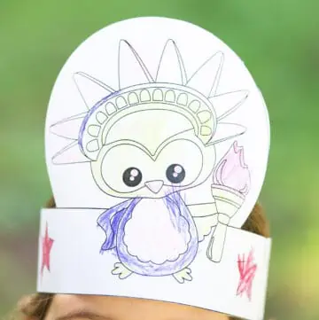 A child wearing a printable Fourth of July headband craft showing an owl as the Statue of Liberty
