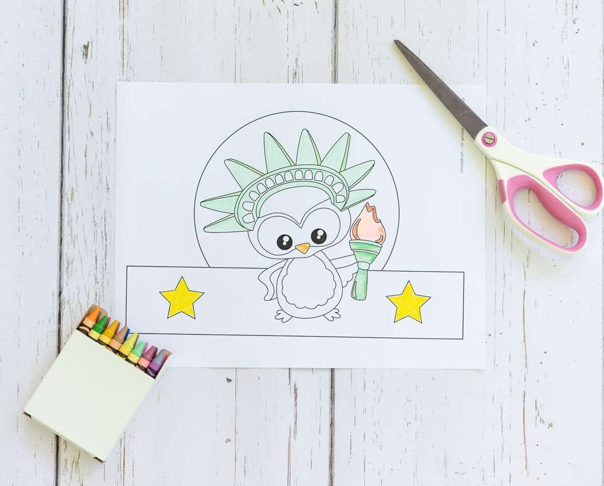 A top down picture of a partially colored State of Liberty owl headband craft