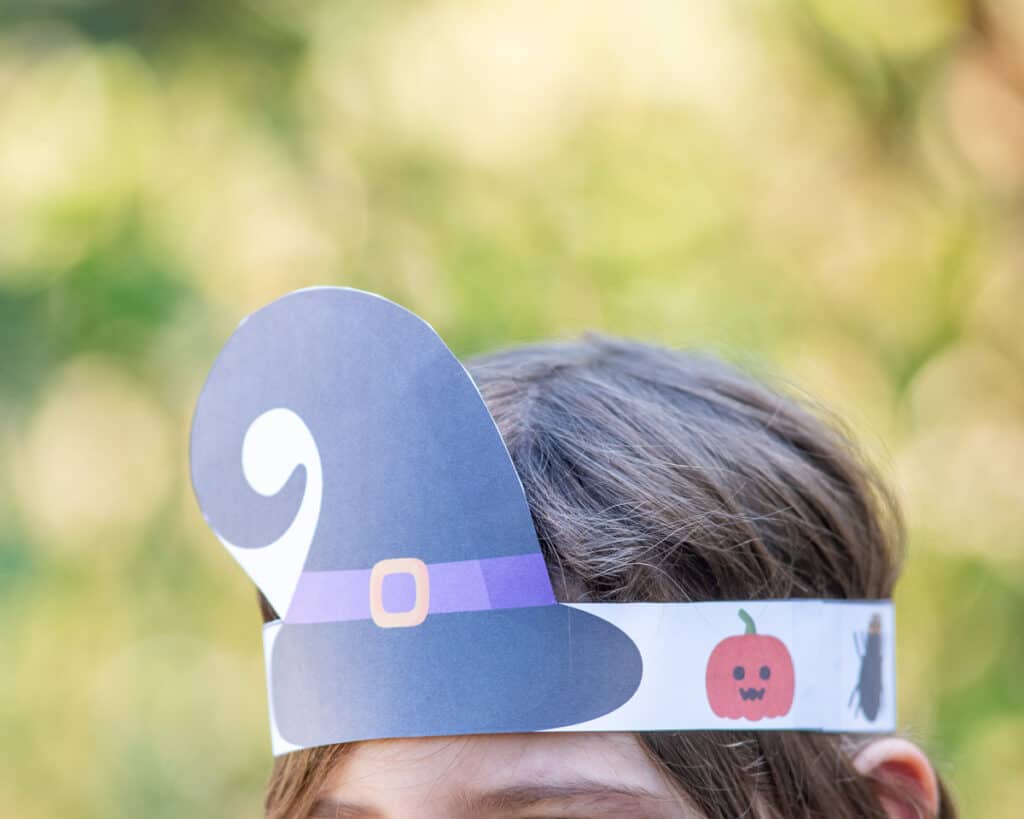 A child wearing a printable witch headband craft.