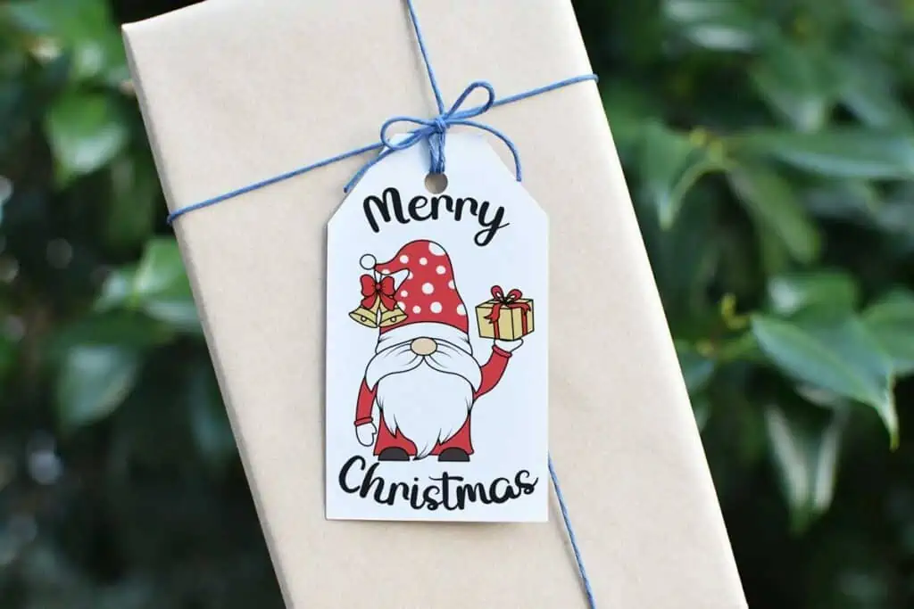 A christmas gift tag with a gnome on a package wrapped with brown paper