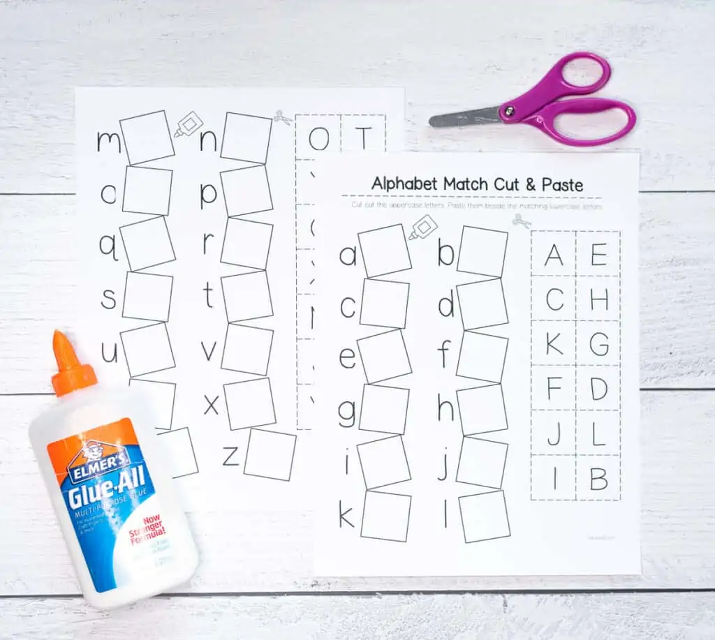 Two pages of a alphabet match cut and paste worksheet with child's scissors and white glue