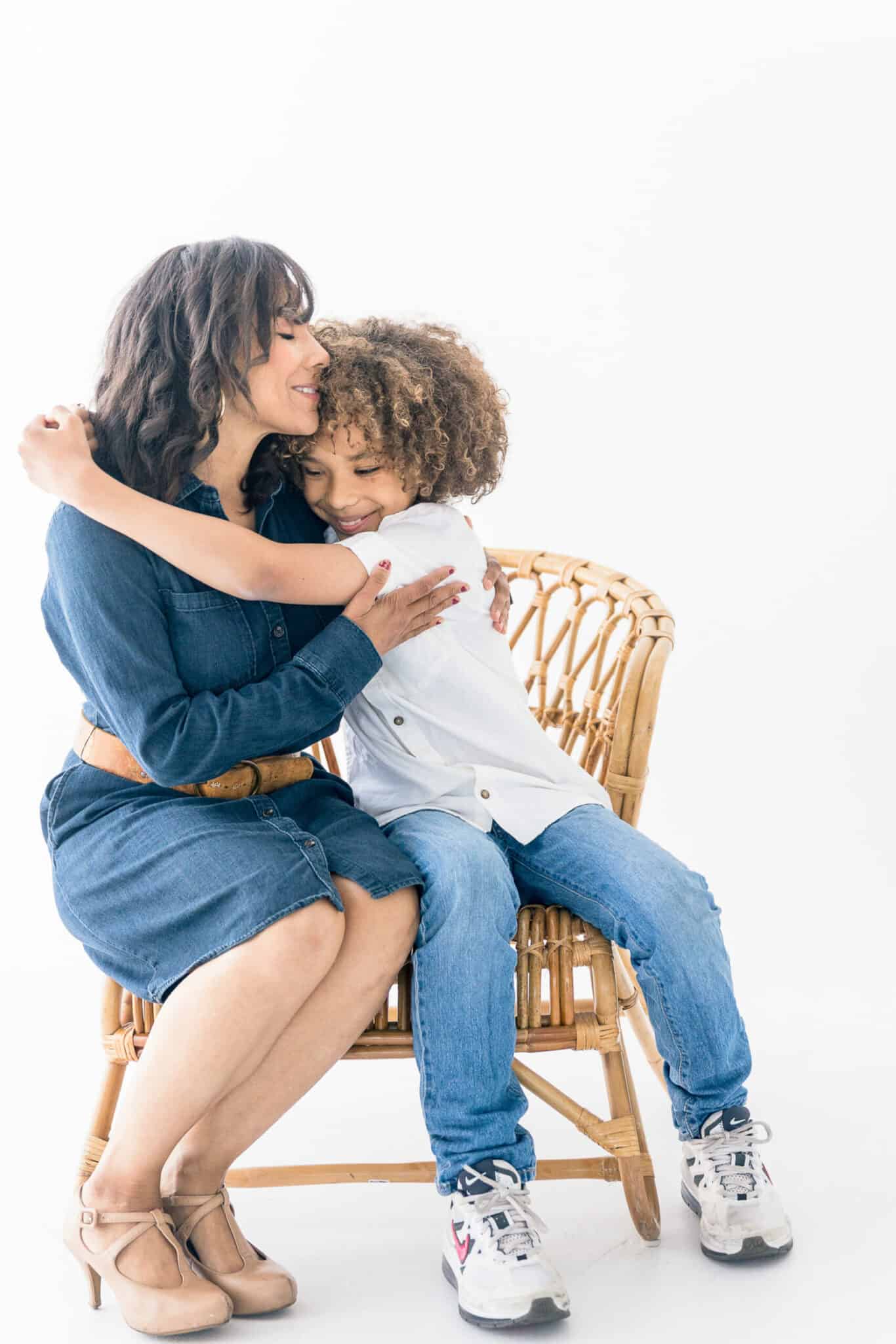A mom and a son hugging on a chair