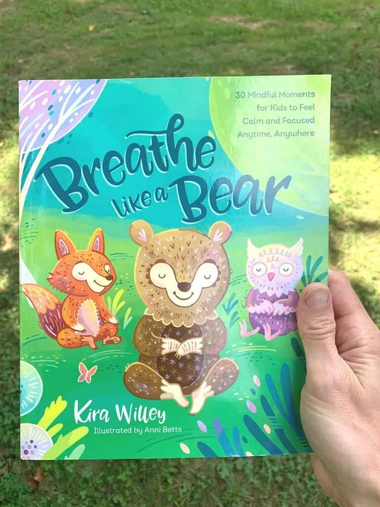 A woman's hand holding the child's book Breathe Like a Bear