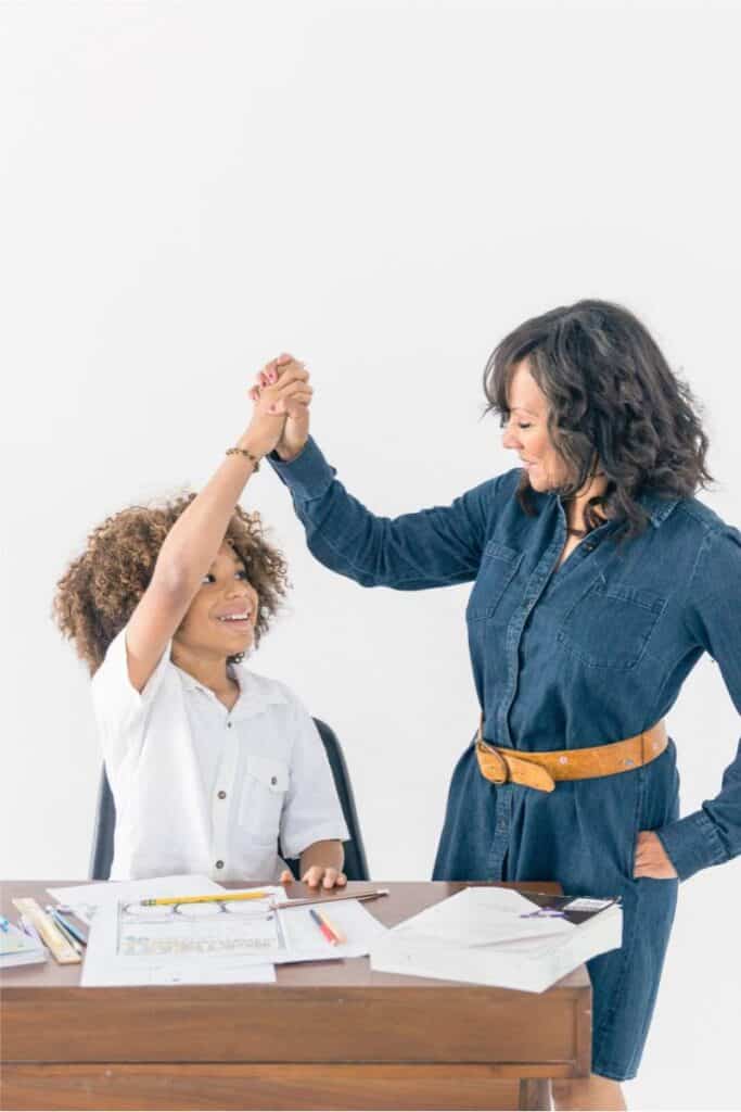 A homeschool mom giving a high five to her son