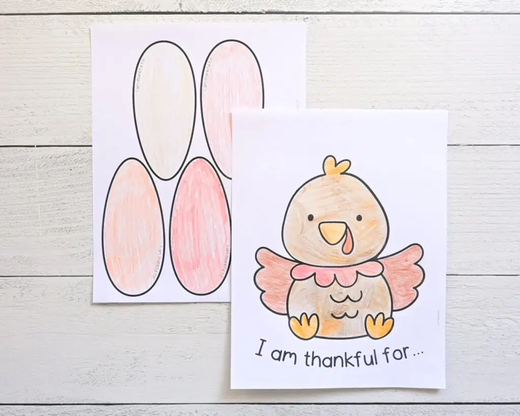 Two printed pages for a thankful turkey Thanksgiving craft. One page has a large cartoon turkey and the text "I am thankful for..." and the other page has five large tail feathers. The pages are colored with pencil.