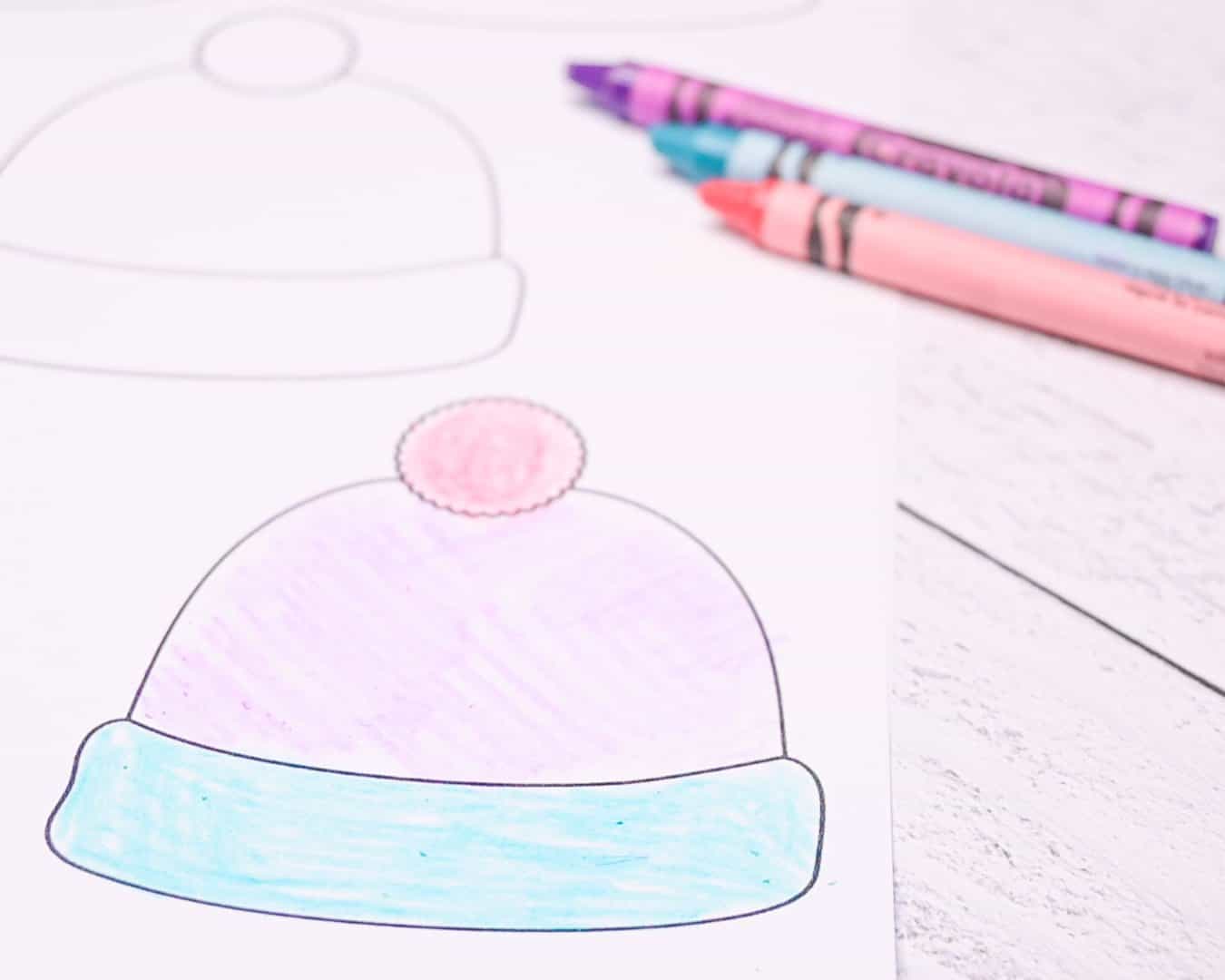 A close up photo of a small winter hat template printable with crayons.