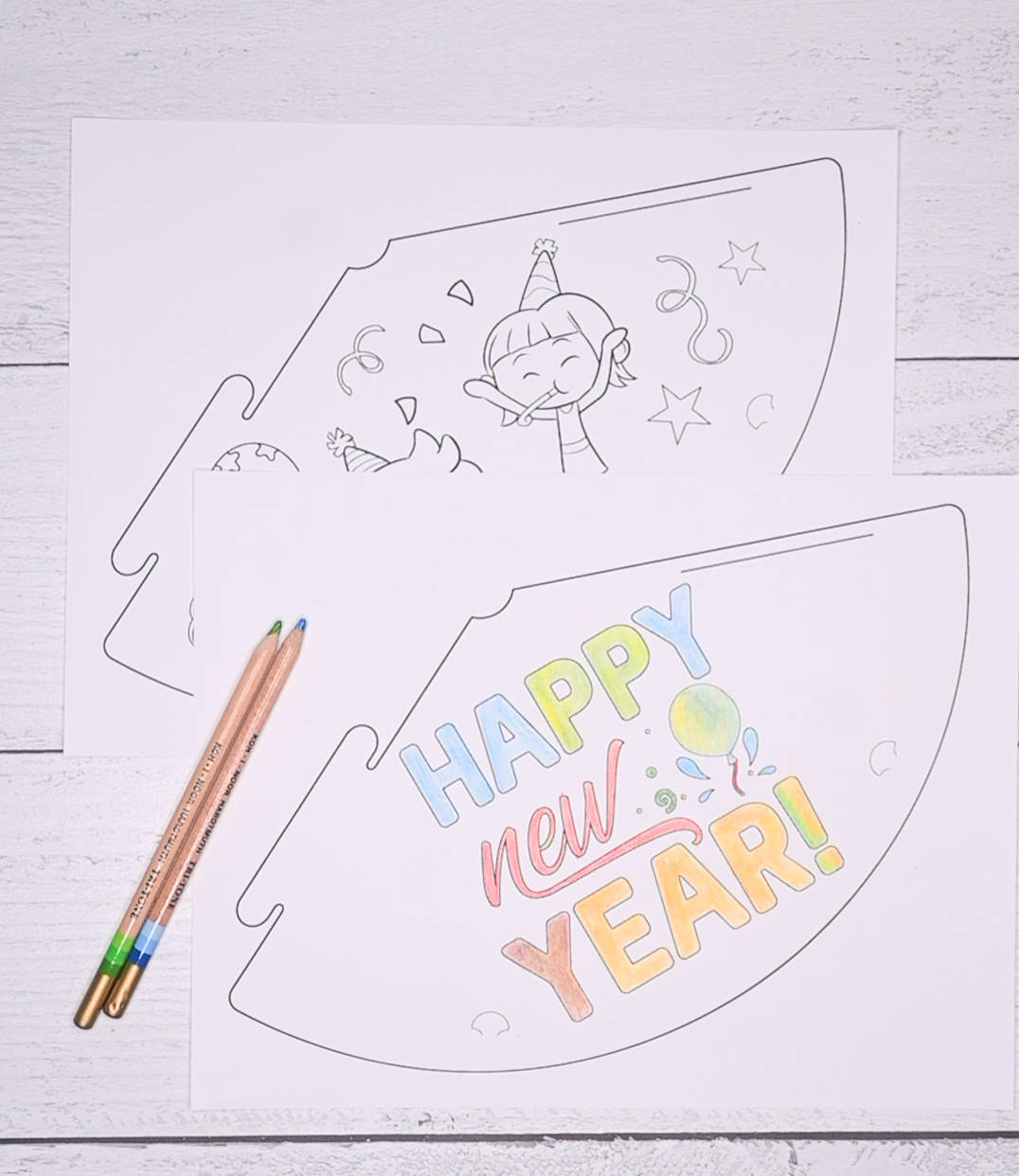 A picture of two printable  New Year's party hats. One is colored, one is not. Neither are cut out.