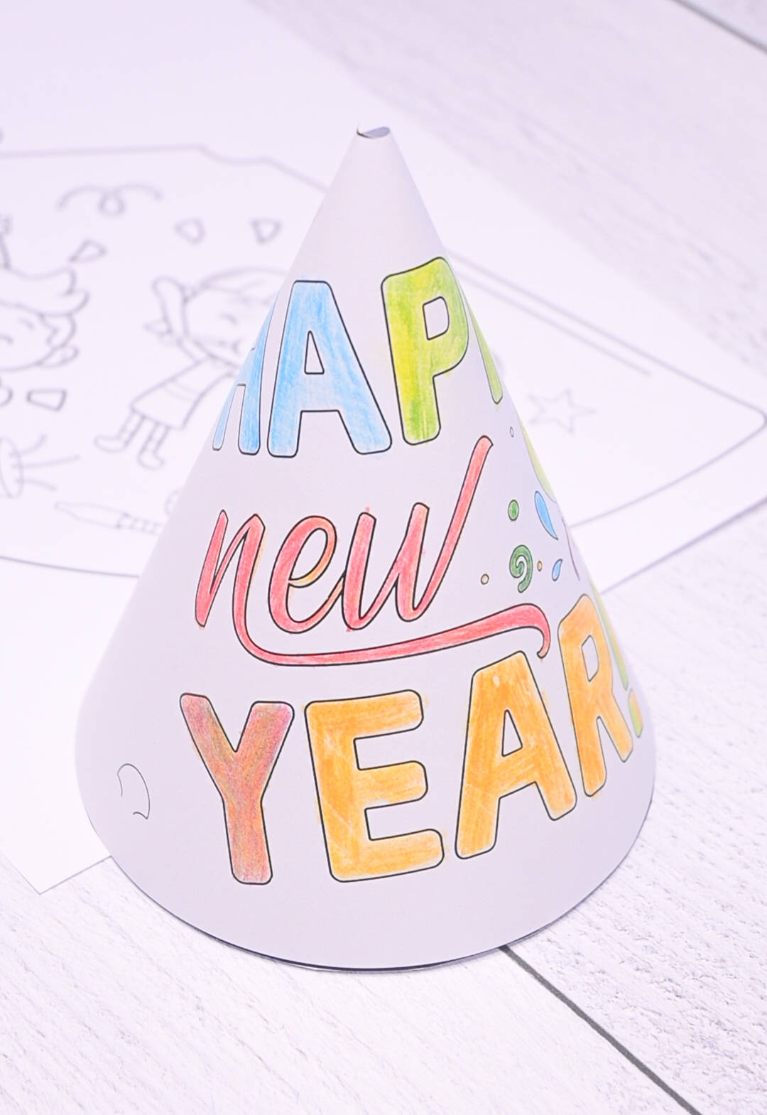 a colored and assembled paper party hat with the text "Happy New Year"
