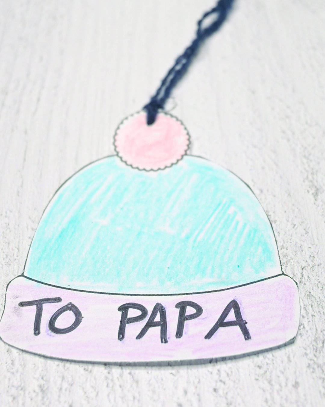 A gift tag in the shape of a hat with the text "to Papa" written on it