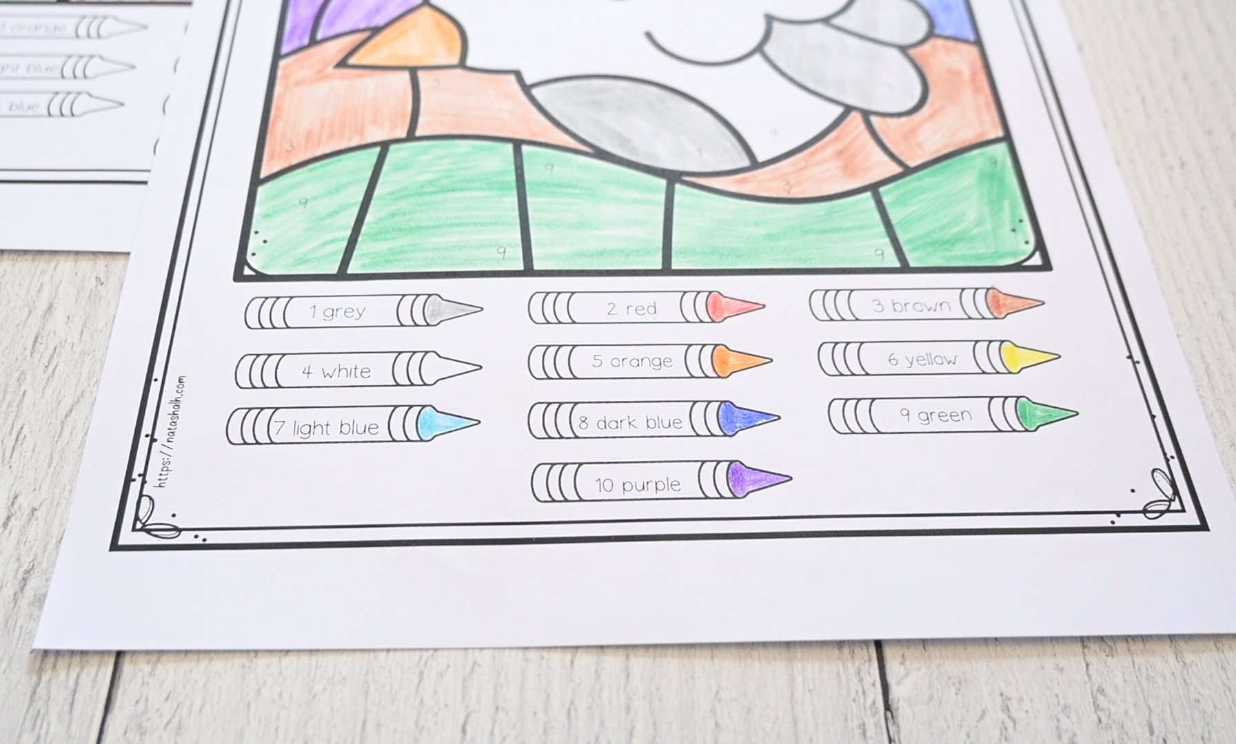 A photograph of a color by number page with numbers 1-10 and crayon tips colored with the appropriate color to make a key for children